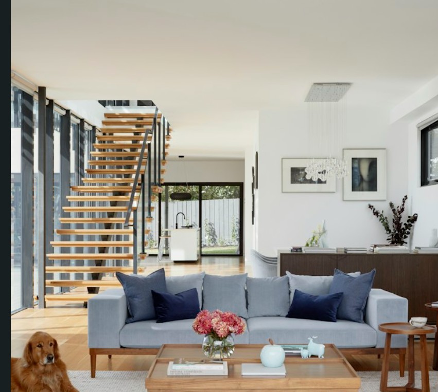 Modern living room with staircase, sofa and dog